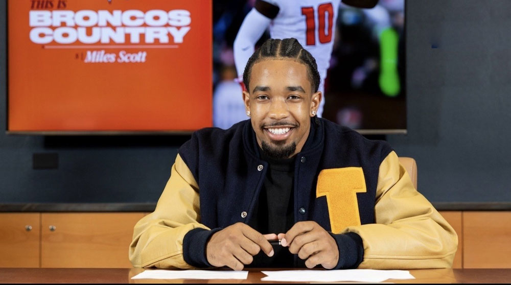 Athlete in a letterman jacket speaking during a televised sports interview